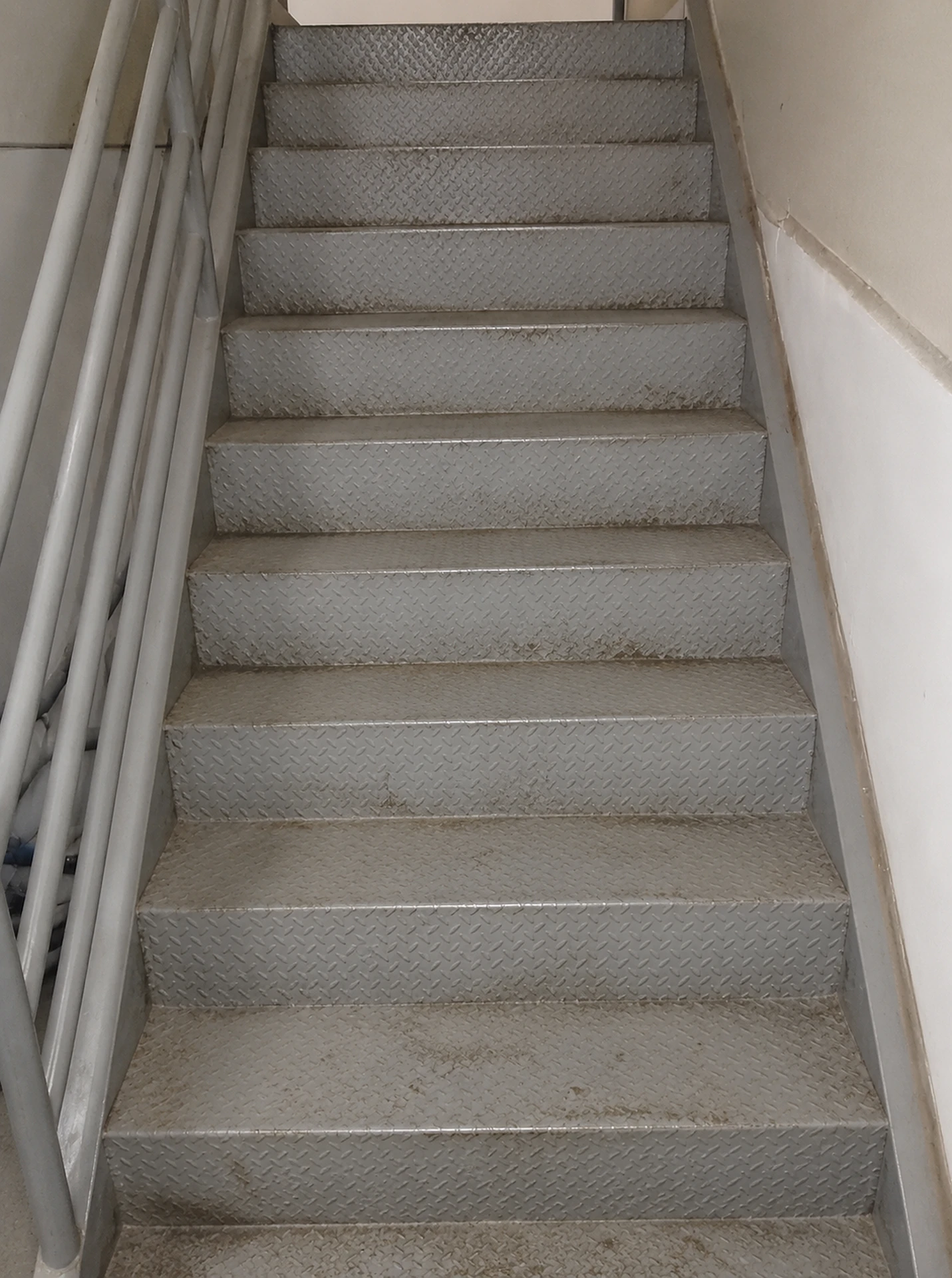 Escada metálica com degraus desgastados e sujos antes dos serviços de limpeza e pintura