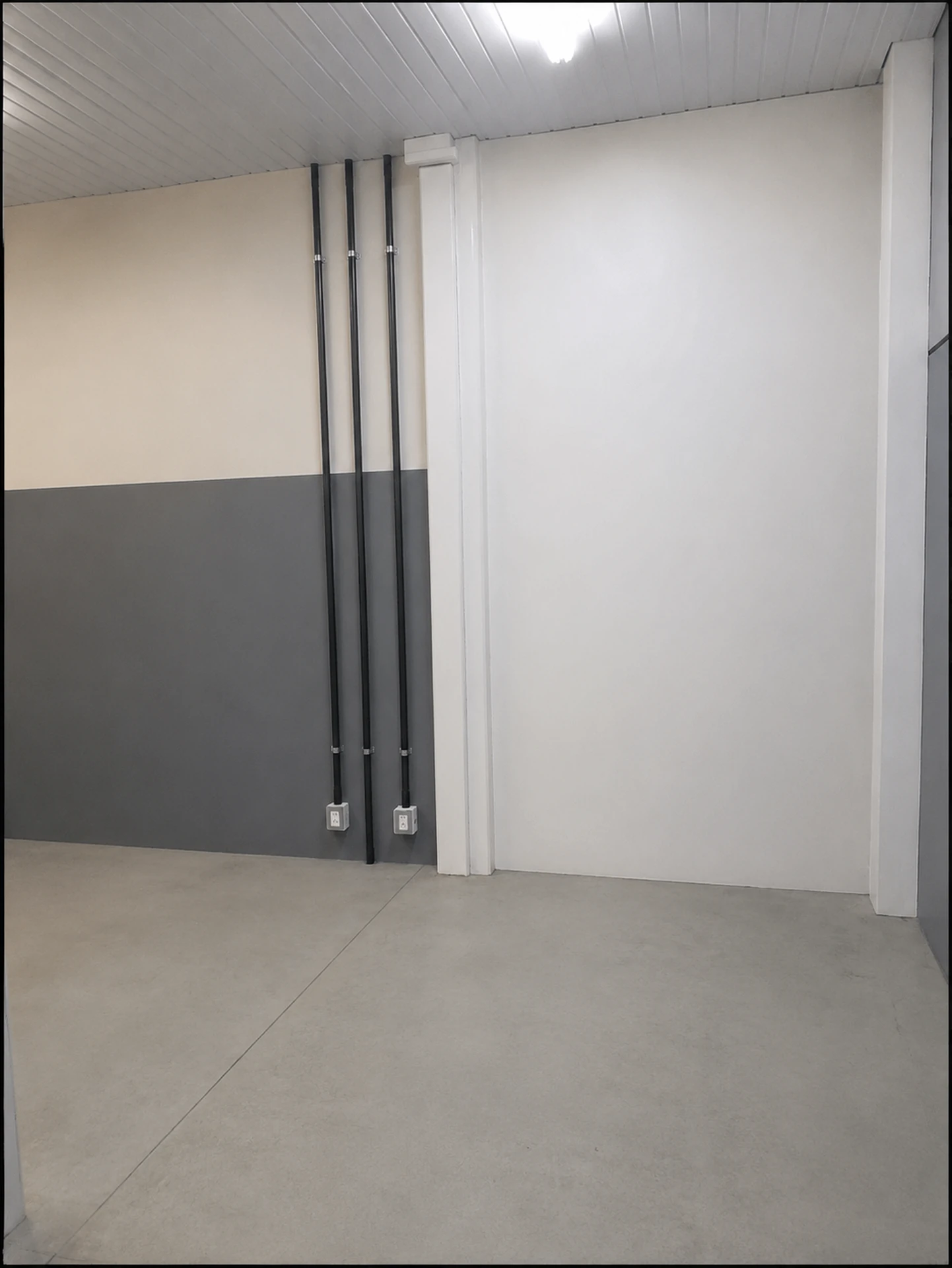 Ambiente finalizado com paredes pintadas, eletrodutos organizados e divisória de drywall instalada