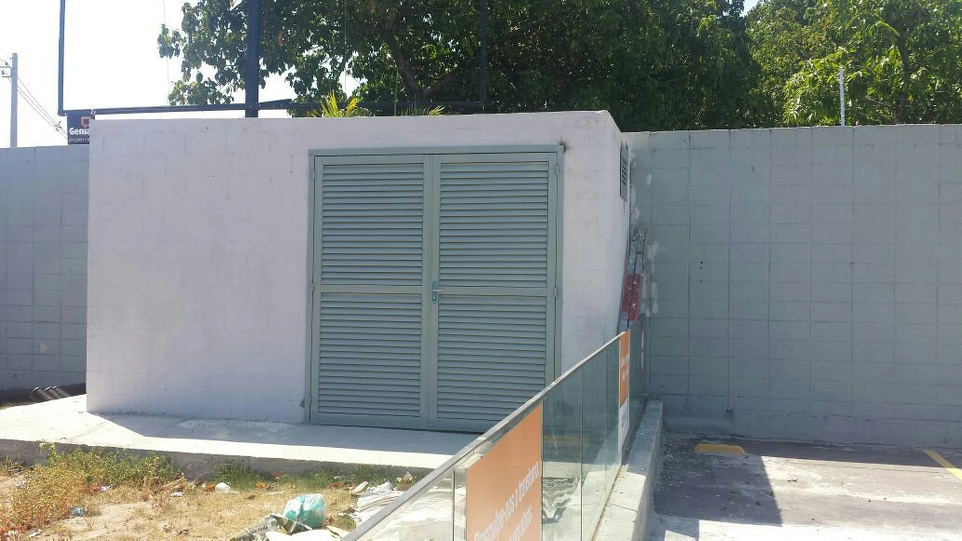 Edícula técnica concluída com porta de veneziana metálica e alvenaria pintada em branco