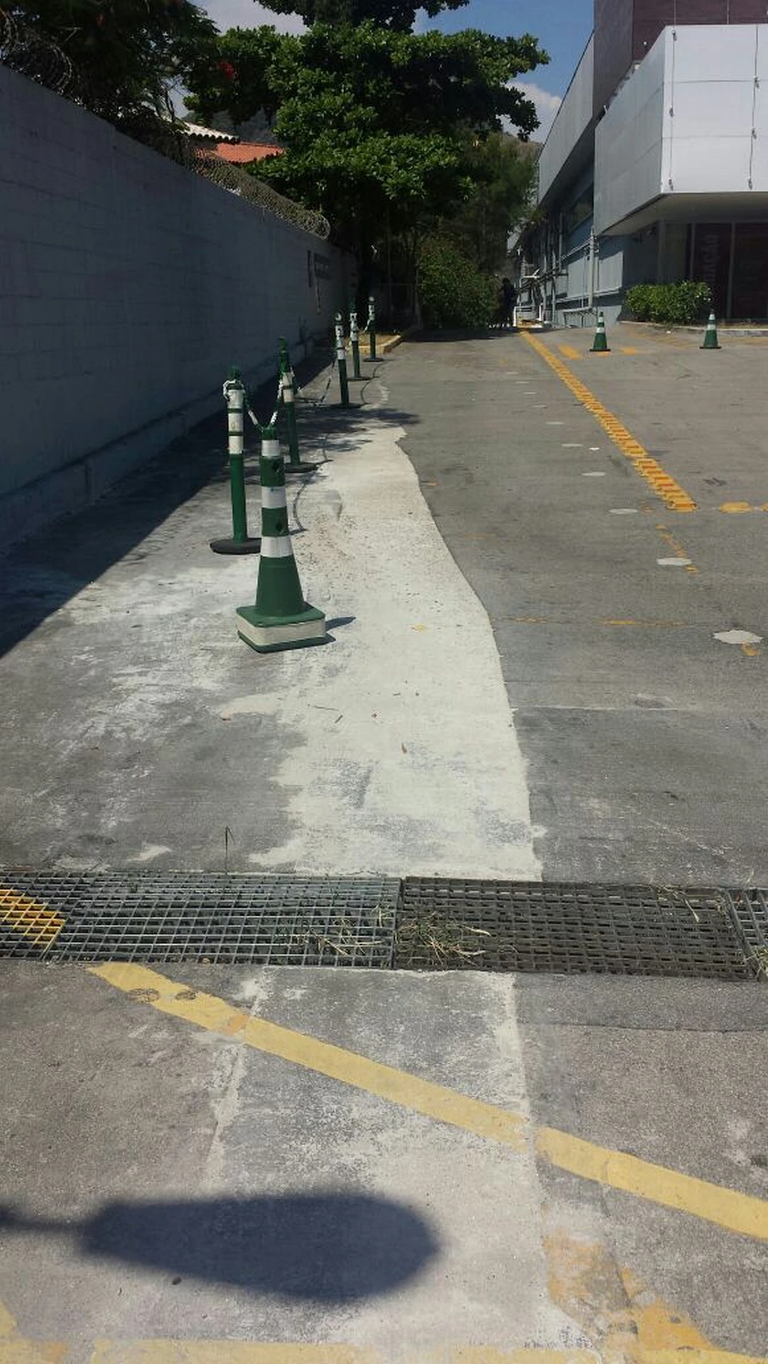 Área de acesso com balizadores e piso de concreto na lateral do empreendimento