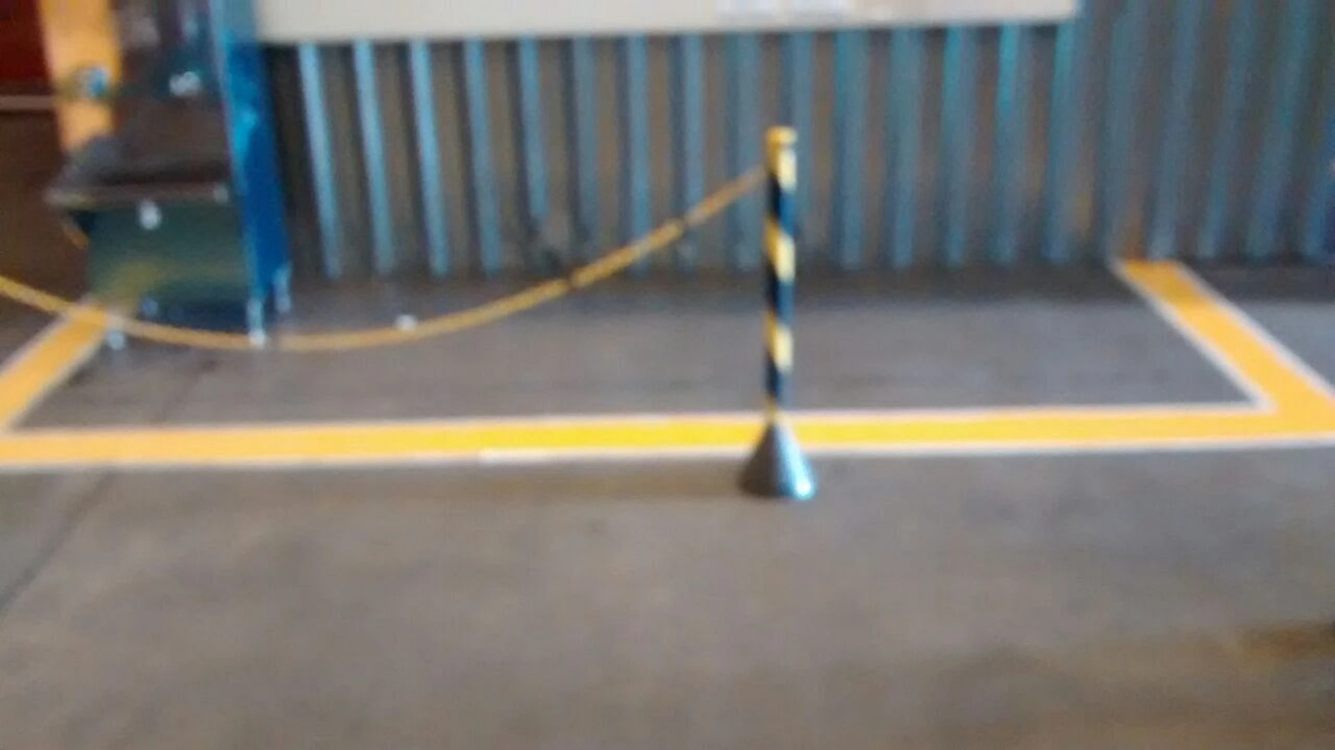 Área de piso delimitada por demarcação amarela com cone de sinalização no centro