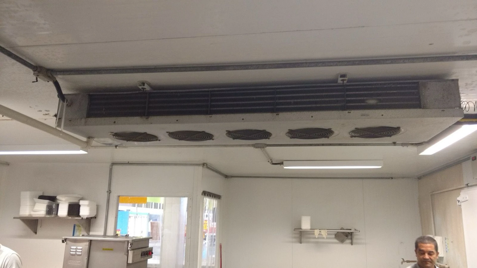 Evaporador de refrigeração instalado no teto com sujidade acumulada antes da manutenção